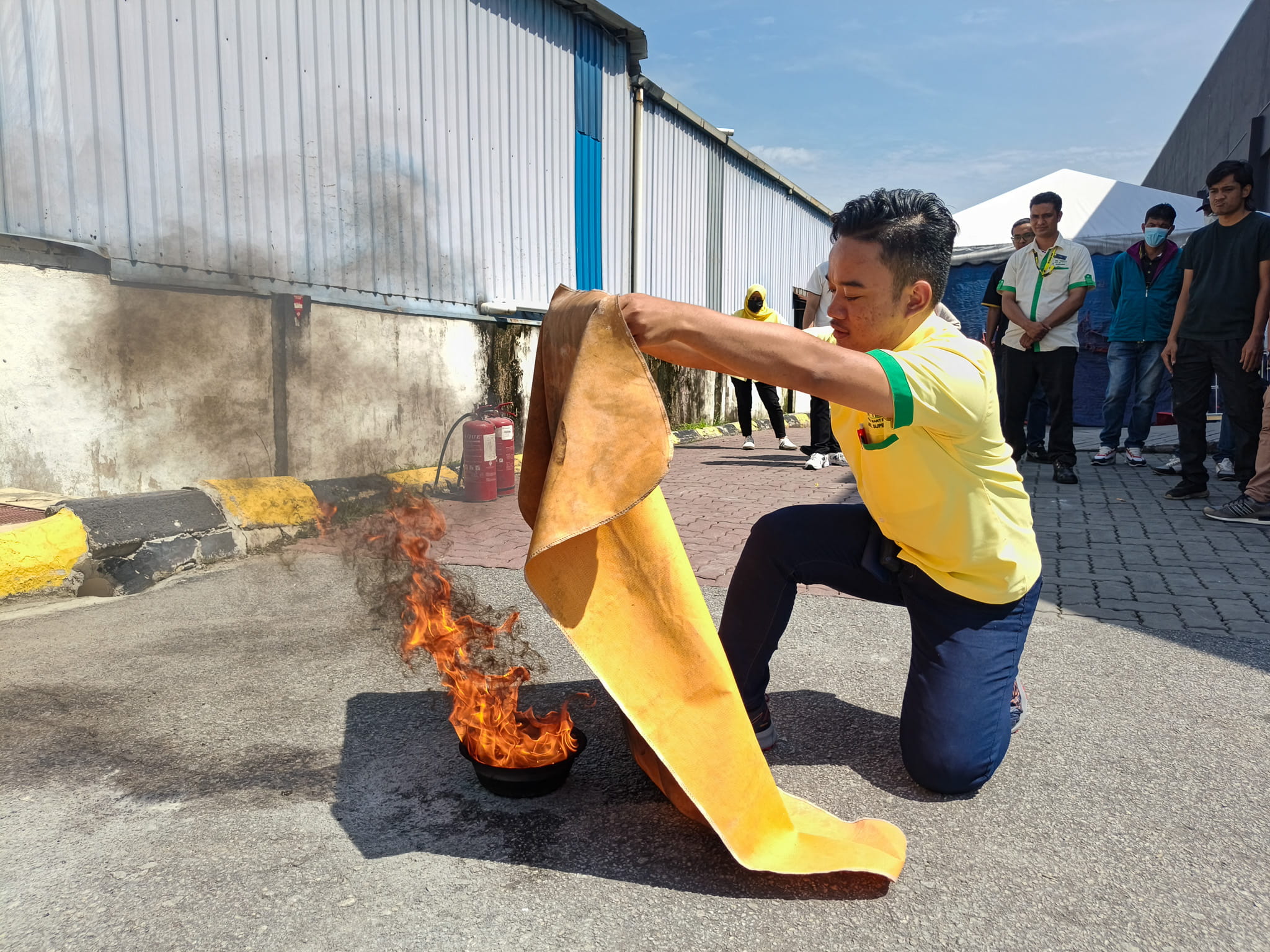 a man putting out a small fire using a towel