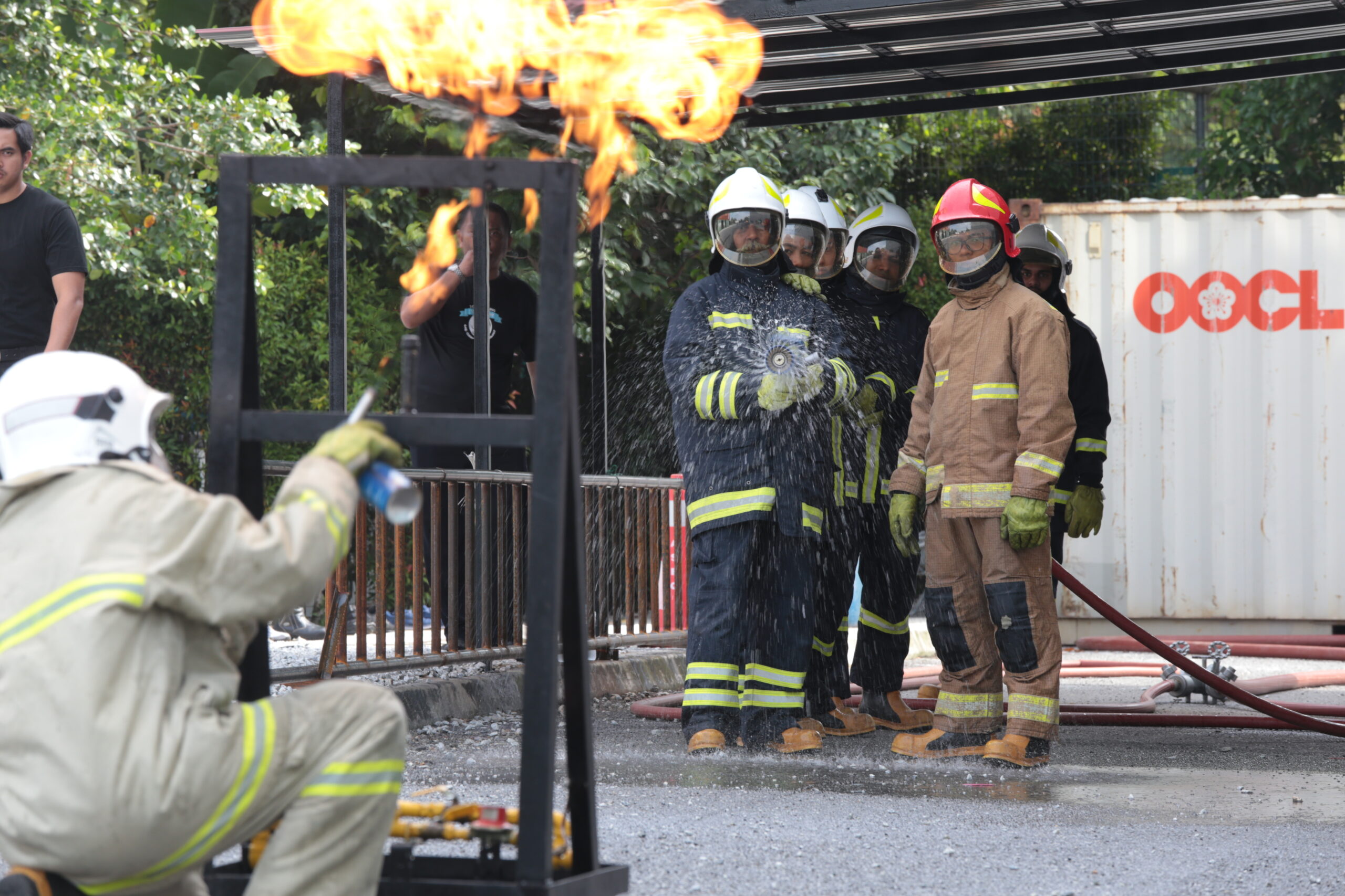 Participants practising hose handling during Firefighting training