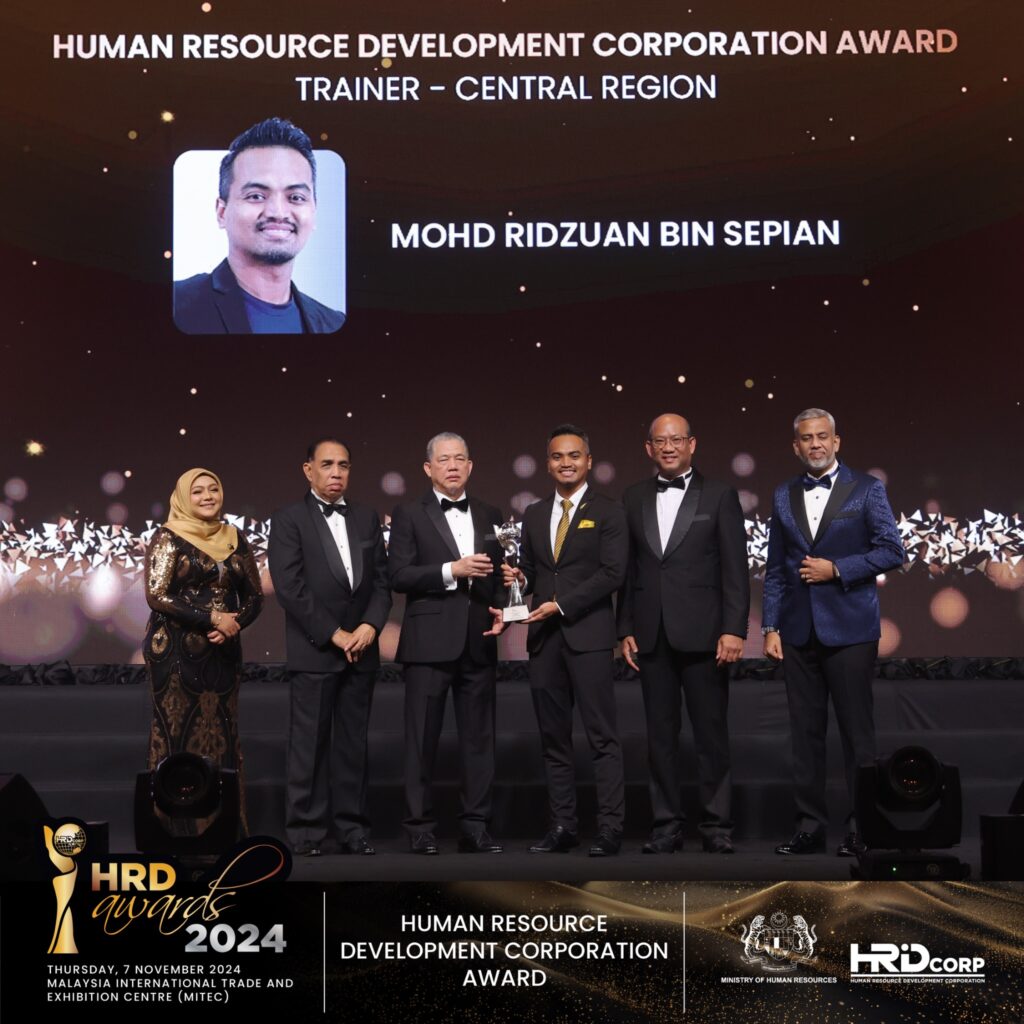 Mohd Ridzuan Bin Sepian receiving the HRD Corp Trainer Award 2024 at the Malaysia International Trade and Exhibition Centre (MITEC), Kuala Lumpur.