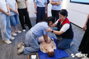 a trainer guiding a person to perform CPR training on a manikin