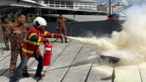 firefighter using fire extinguisher to put out fire