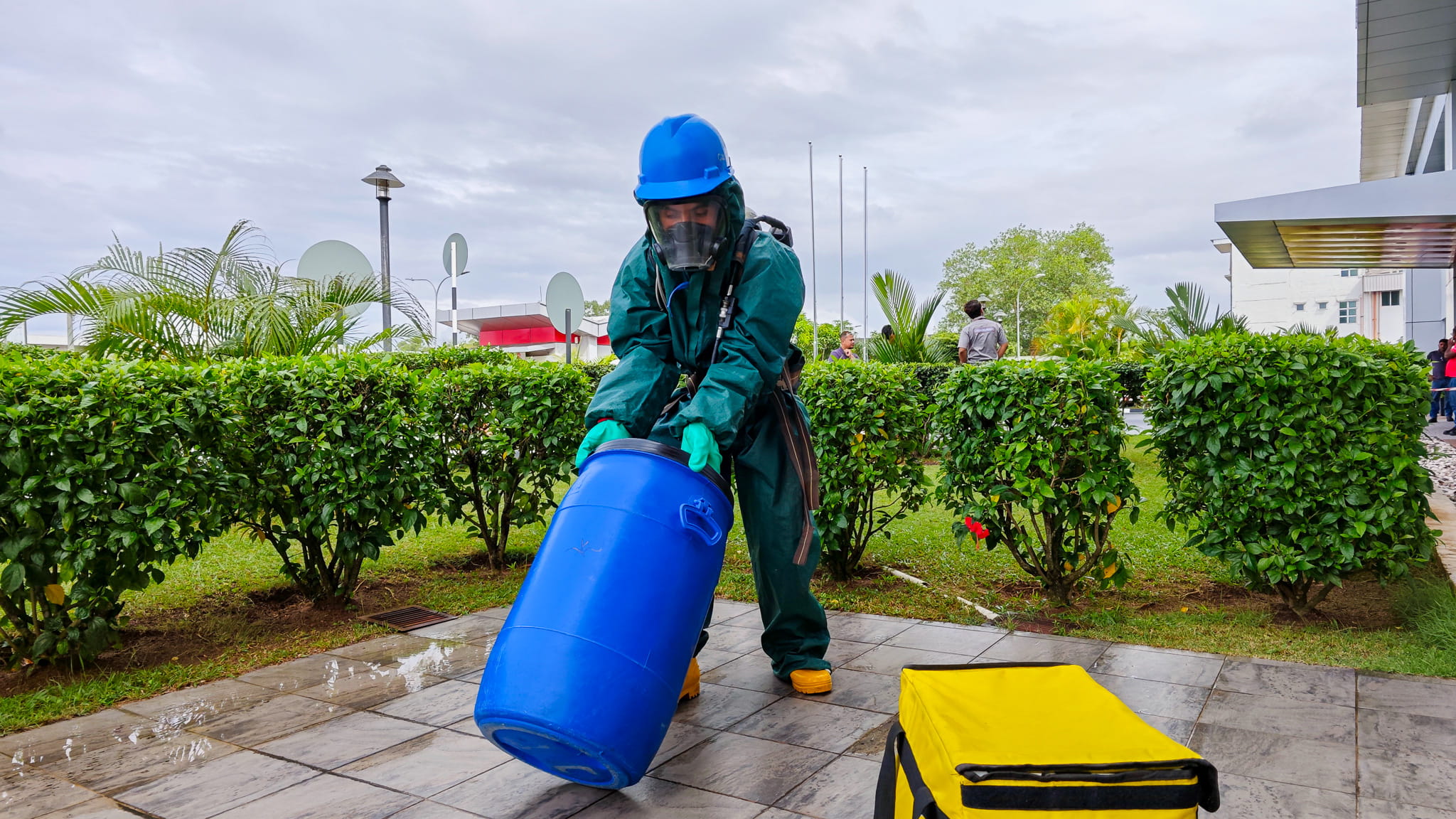 a person wearing firefighting gear carrying a blue container