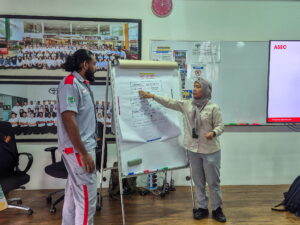 a woman pointing at a whiteboard