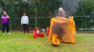 a lady putting out fire with a big cloth