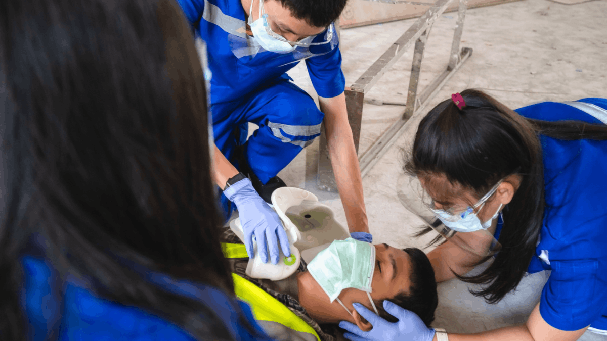 trainers asessing a man that is unconscious