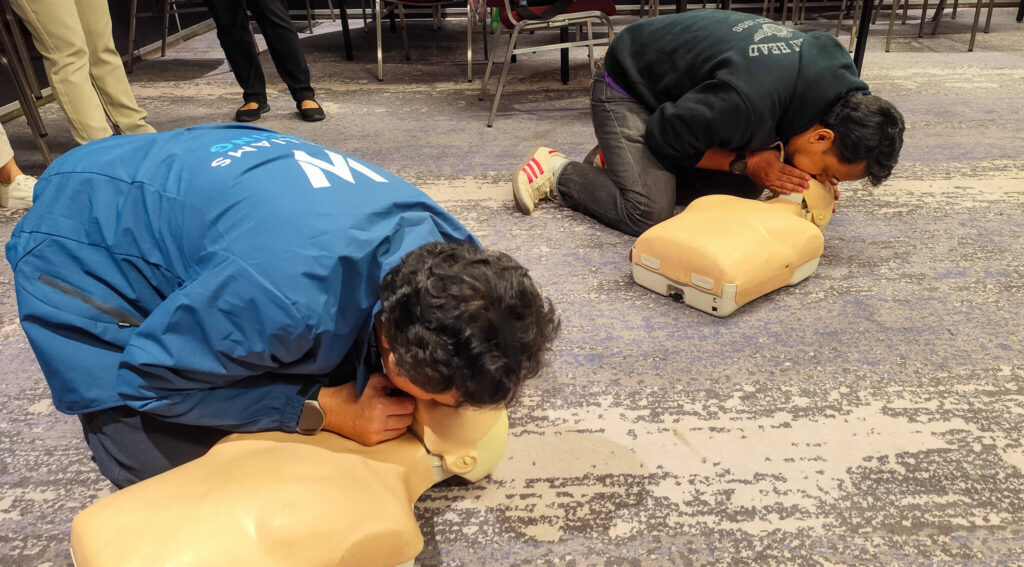 two trainers performing CPR training on manikins