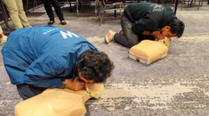 two trainers performing CPR training on manikins