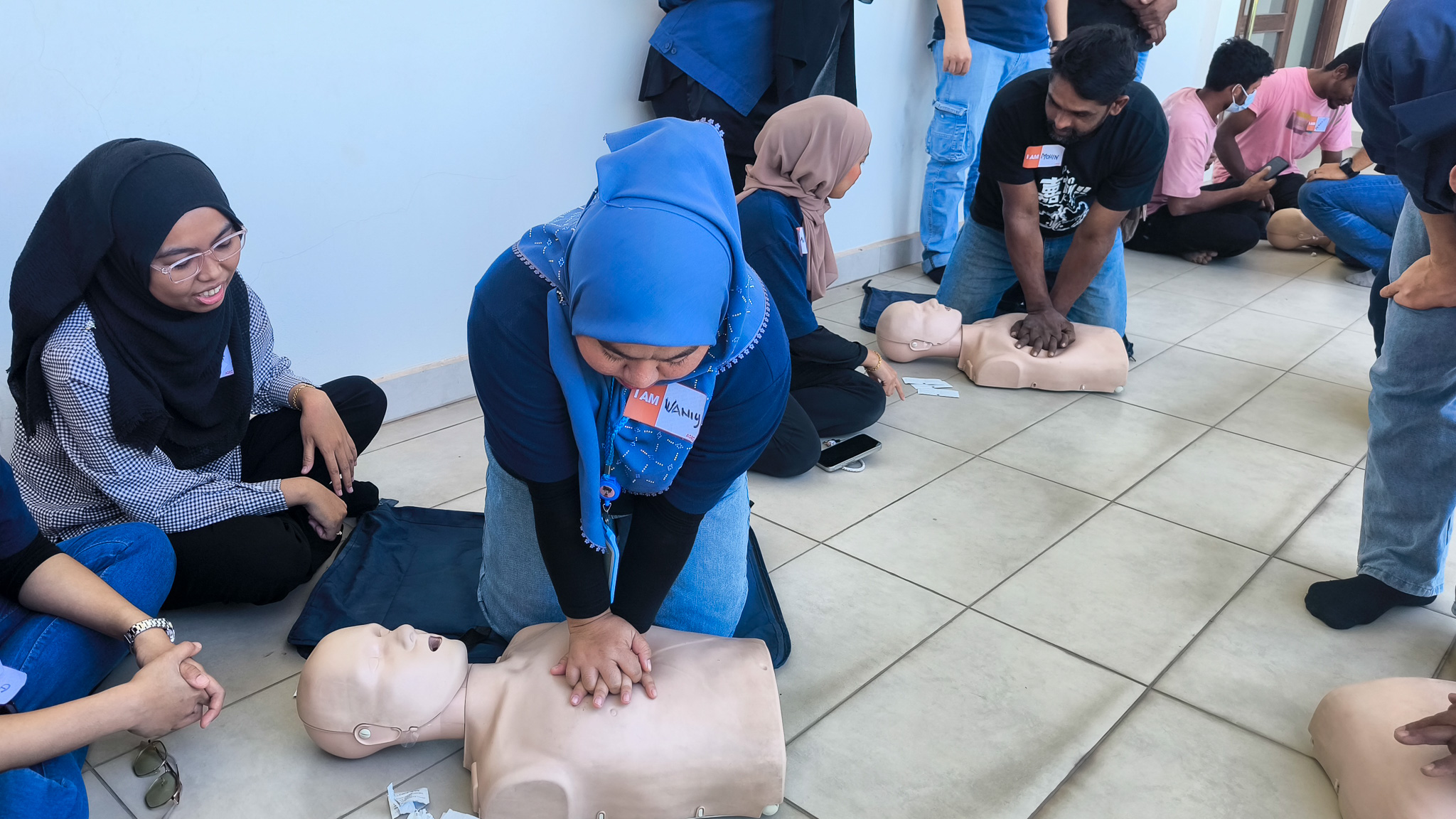 a lady performing CPR training on a manikin